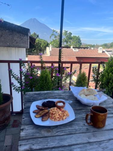 a table with a plate of food on a balcony at Jireh guesthouse in Antigua Guatemala