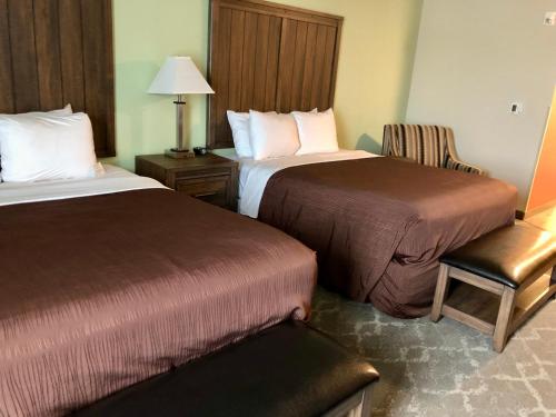 a hotel room with two beds and a chair at Aspen Suites Hotel Homer in Homer