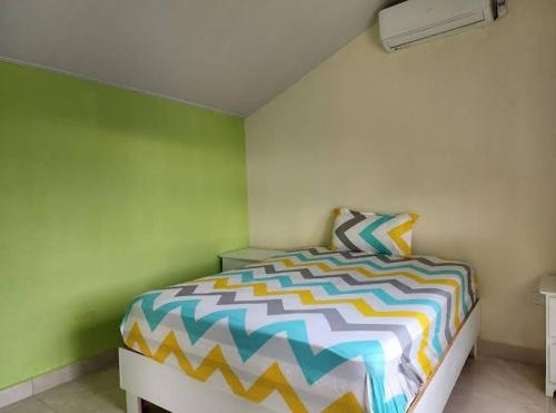 a bedroom with a bed with a colorful comforter at Villa Janel in Punta Rucia