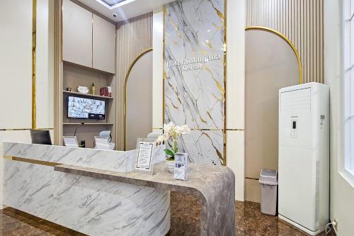a reception desk in a lobby with a marble counter at Sans Vibes Hotel Sulanjana Syariah Sukabumi in Krawang