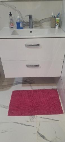 a red rug on the floor under a bathroom sink at Suites au sein d'une Villa au centre ville de Rabat in Rabat