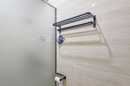 a bathroom with a mirror and a towel rack at Sans Vibes Hotel Sulanjana Syariah Sukabumi in Krawang