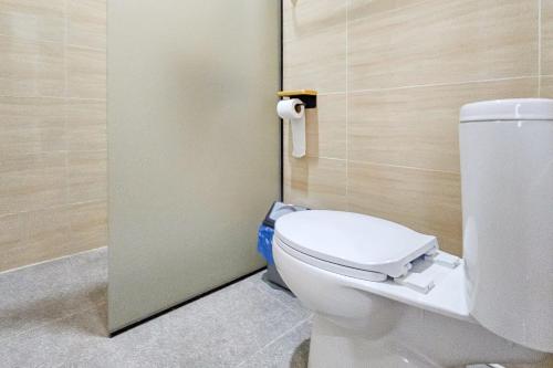 a bathroom with a white toilet in a stall at Sans Vibes Hotel Sulanjana Syariah Sukabumi in Krawang