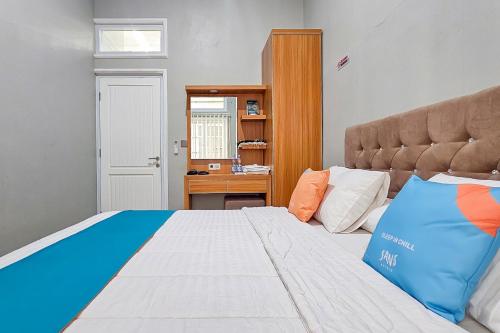 a bedroom with a large bed and a desk at Sans Vibes Hotel Sulanjana Syariah Sukabumi in Krawang