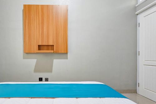 a bedroom with a bed and a wooden cabinet at Sans Vibes Hotel Sulanjana Syariah Sukabumi in Krawang