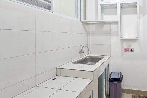 a white kitchen with a sink and a window at Sans Vibes Hotel Sulanjana Syariah Sukabumi in Krawang