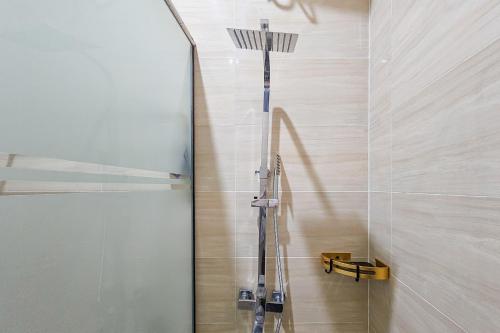 a shower with a glass door in a bathroom at Sans Vibes Hotel Sulanjana Syariah Sukabumi in Krawang