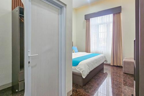 a bedroom with a bed and a sliding glass door at Sans Vibes Hotel Sulanjana Syariah Sukabumi in Krawang