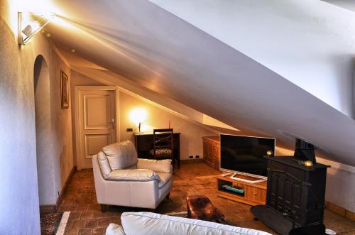 a living room with a couch and a tv at Locanda Colle Cerqueto in Fiumata