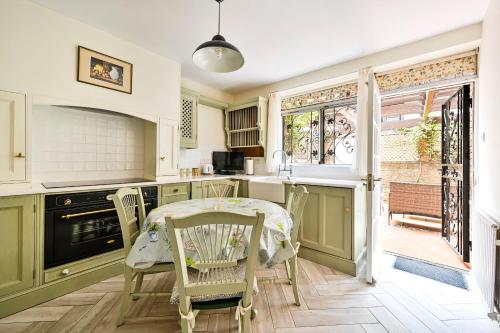 a kitchen with a table and chairs and a window at bloomrooms@Knightsbridge/HydePark in London