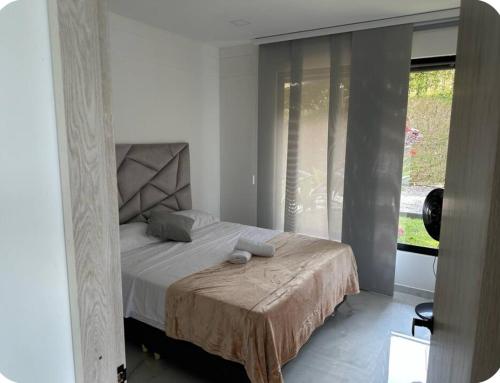 a bedroom with a bed and a large window at Casa con Terraza y Vista Espectacular a la Naturaleza in Dosquebradas