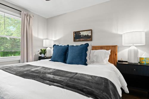 a bedroom with a large white bed with blue pillows at New! Private Lakefront Retreat 3BR 2BA Game Room 