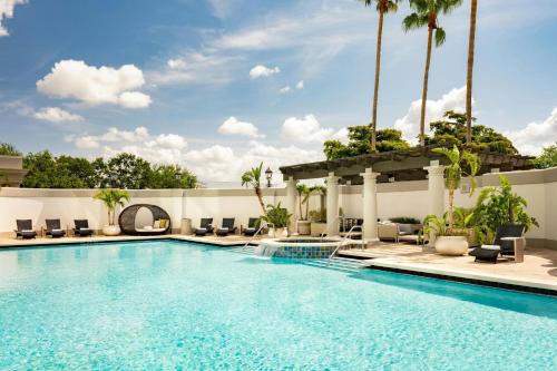 a pool at a hotel with chairs and palm trees at Renaissance Tampa International Plaza Hotel in Tampa