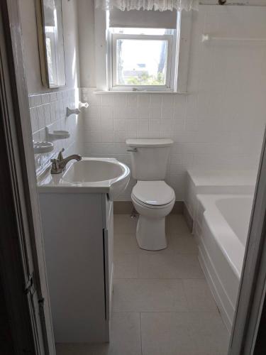 a bathroom with a toilet and a sink and a tub at Ocean Breeze Retreat in Beach Haven