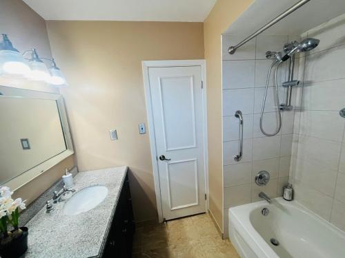 a bathroom with a sink and a tub and a shower at Cozy Stay, Self Check-In with Parking available upon request in Toronto