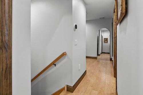 a hallway with white walls and wood floors and a stairway at Newly Built Home Perfectly Located Near Skippack! in Schwenksville