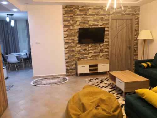 a living room with a tv on a brick wall at Le nid d'Azur tipaza in Tipaza