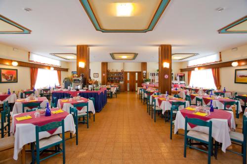 un comedor con mesas y sillas con manteles azules y blancos en Hotel Bettina, en Lido di Jesolo