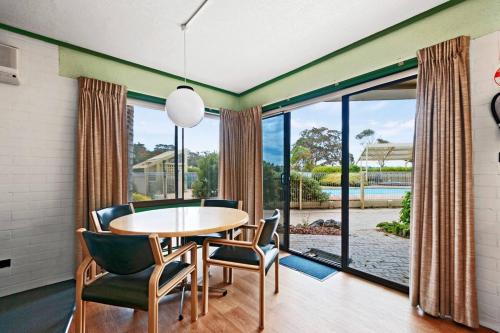 a dining room with a table and chairs and a large window at Comfort Inn & Suites Lakes Entrance in Lakes Entrance