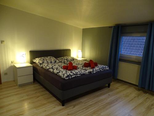 a bedroom with a bed with red pillows on it at Fewo-Nordseebaer in Friedrichskoog