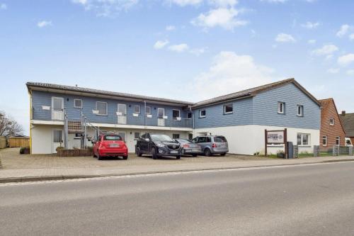 a blue building with cars parked in a parking lot at Fewo-Nordseebaer in Friedrichskoog