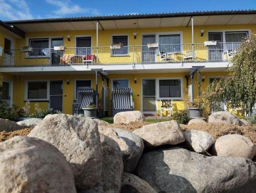 a yellow building with rocks in front of it at Fewo-Nordseeanker in Friedrichskoog