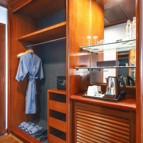 a walk in closet with wooden cabinets and a kitchen at Royal Phuket City Hotel in Phuket Town