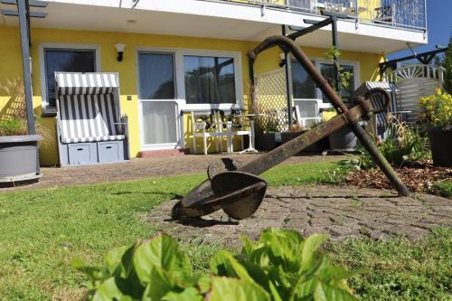 an old rake in a yard in front of a house at Fewo-Seegras in Friedrichskoog