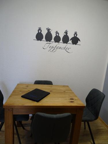 a table with a table with four black birds on it at Fewo-Seemoewe in Friedrichskoog