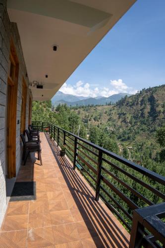a balcony with benches and a view of the mountains at sharan stay in Nagar