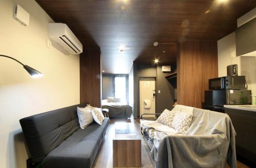 a living room with a couch and a kitchen at S-rea TOKYO in Tokyo