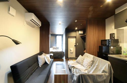 a living room with a couch and a kitchen at S-rea TOKYO in Tokyo
