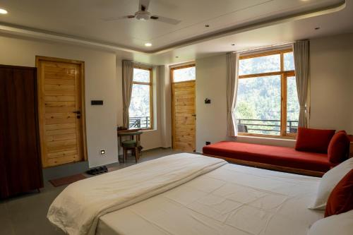a bedroom with a large bed and a red couch at sharan stay in Nagar
