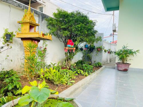 a garden with a yellow bird house on the side of a building at TATEK Villa in Kampot