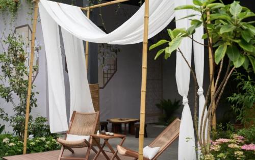 a patio with a white canopy and chairs and a table at Yinxitang Aesthetic Life Courtyard Hotel Kuanzhai Alley People's Park Subway Station Branch in Chengdu