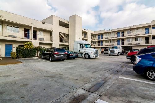 a parking lot with cars parked in front of a building at Motel 6 Bell Gardens, CA - Los Angeles in Bell Gardens