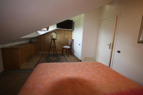 a bedroom with a bed with an orange blanket on it at Locanda Colle Cerqueto in Fiumata