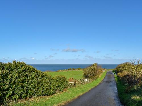 a road with the ocean in the background at Eryl Mor Lodge in Amlwch