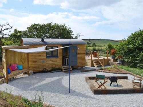 a tiny house with a tent and a swing at The Wool Shed in Saint Ewe