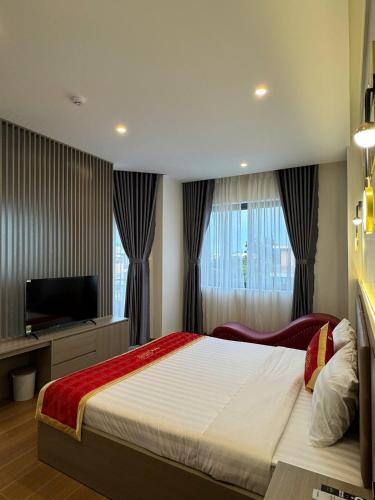 a bedroom with a large bed and a television at Hotel 168 Rạch Giá in Rach Gia
