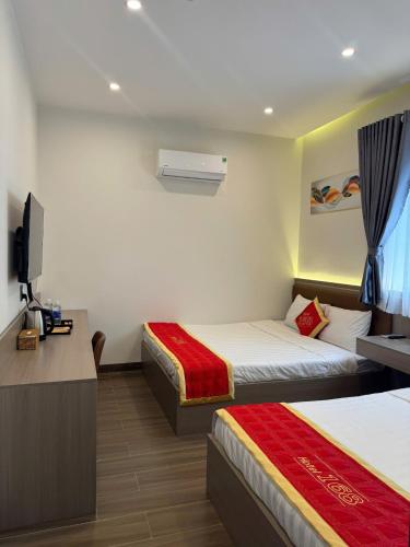 a hotel room with two beds and a television at Hotel 168 Rạch Giá in Rach Gia