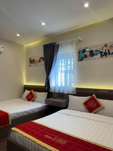 a bedroom with two beds and a window at Hotel 168 Rạch Giá in Rach Gia