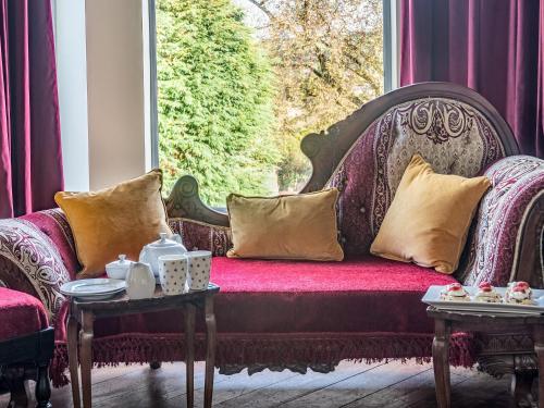 a couch in a window with pillows on it at Groudd Hall in Cerrigydrudion