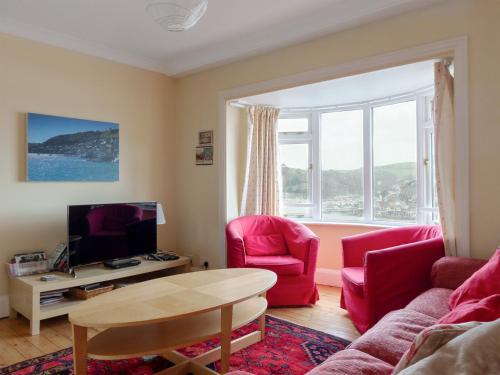 ein Wohnzimmer mit einem Sofa und zwei Sesseln und einem Fernseher in der Unterkunft Larkrise in Kingswear