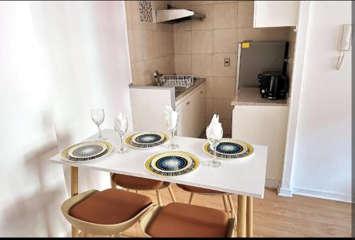 a white table with two plates and chairs in a kitchen at Merced in Santiago
