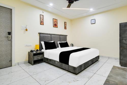 a bedroom with a black and white bed in a room at Hotel O RichFeel in Harsola