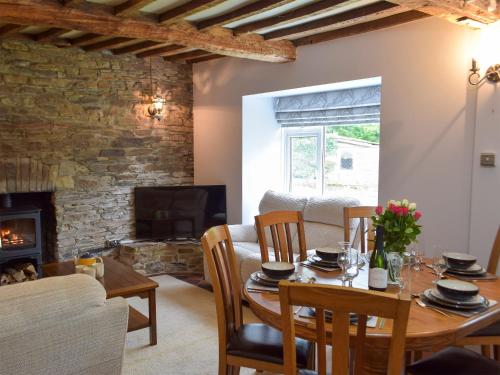 a dining room with a table and a fireplace at The Farmhouse - Uk13183 in Cwm-Morgan