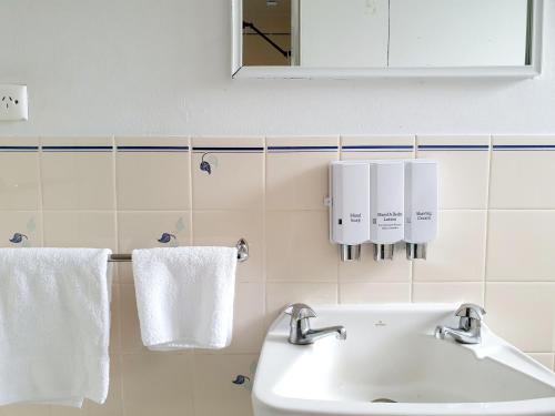 a bathroom with a sink and white towels at Oceanside Hawks Nest in Hawks Nest