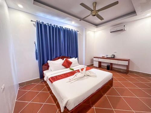 a bedroom with a bed with a ceiling fan at SoonNoeng Resort in Koh Rong Sanloem