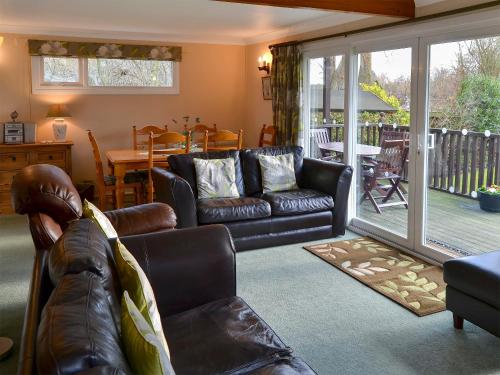 ein Wohnzimmer mit einem Ledersofa und einem Tisch in der Unterkunft The Wherry in Wroxham